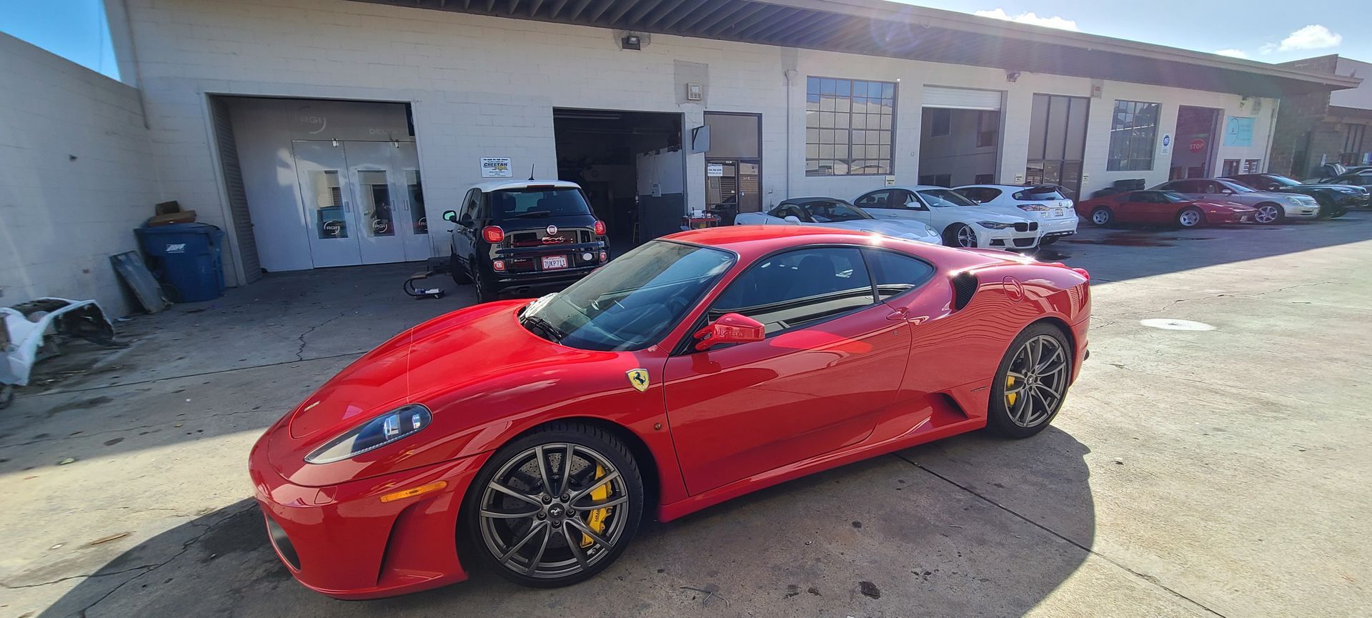 A red ferrari is parked in front of a building.