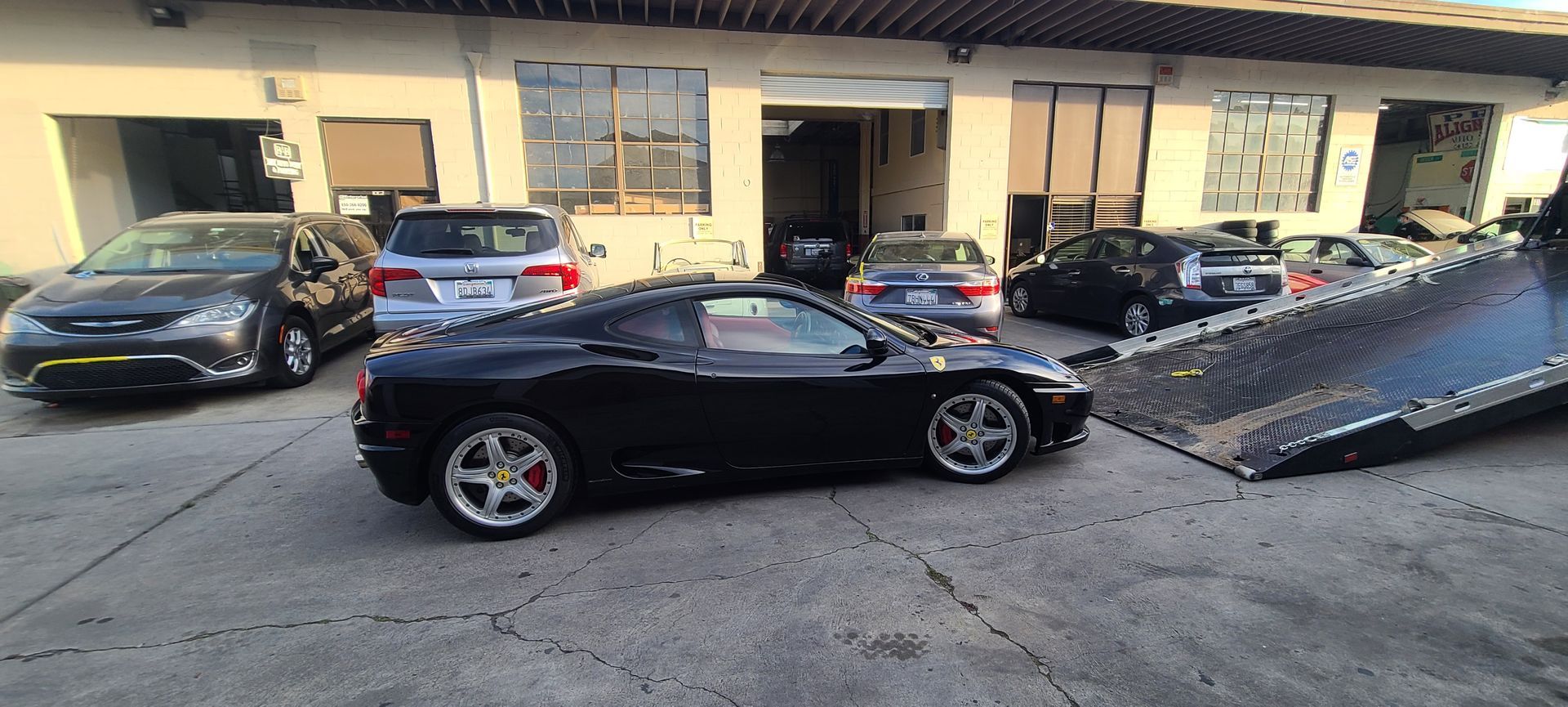 A black sports car is being towed by a tow truck.