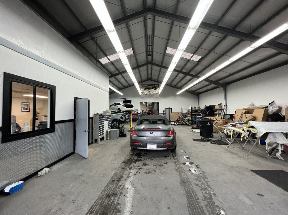 A car is parked in the middle of a garage.