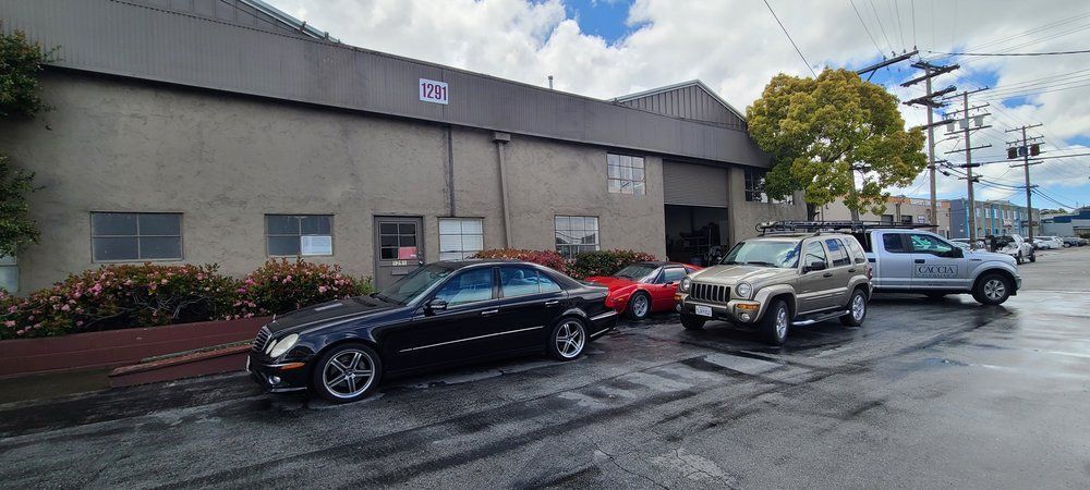 A group of cars are parked in front of a building.