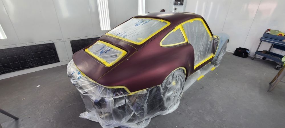 A car is being painted in a paint booth.