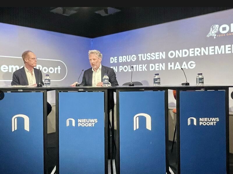 Two men seated at a blue 