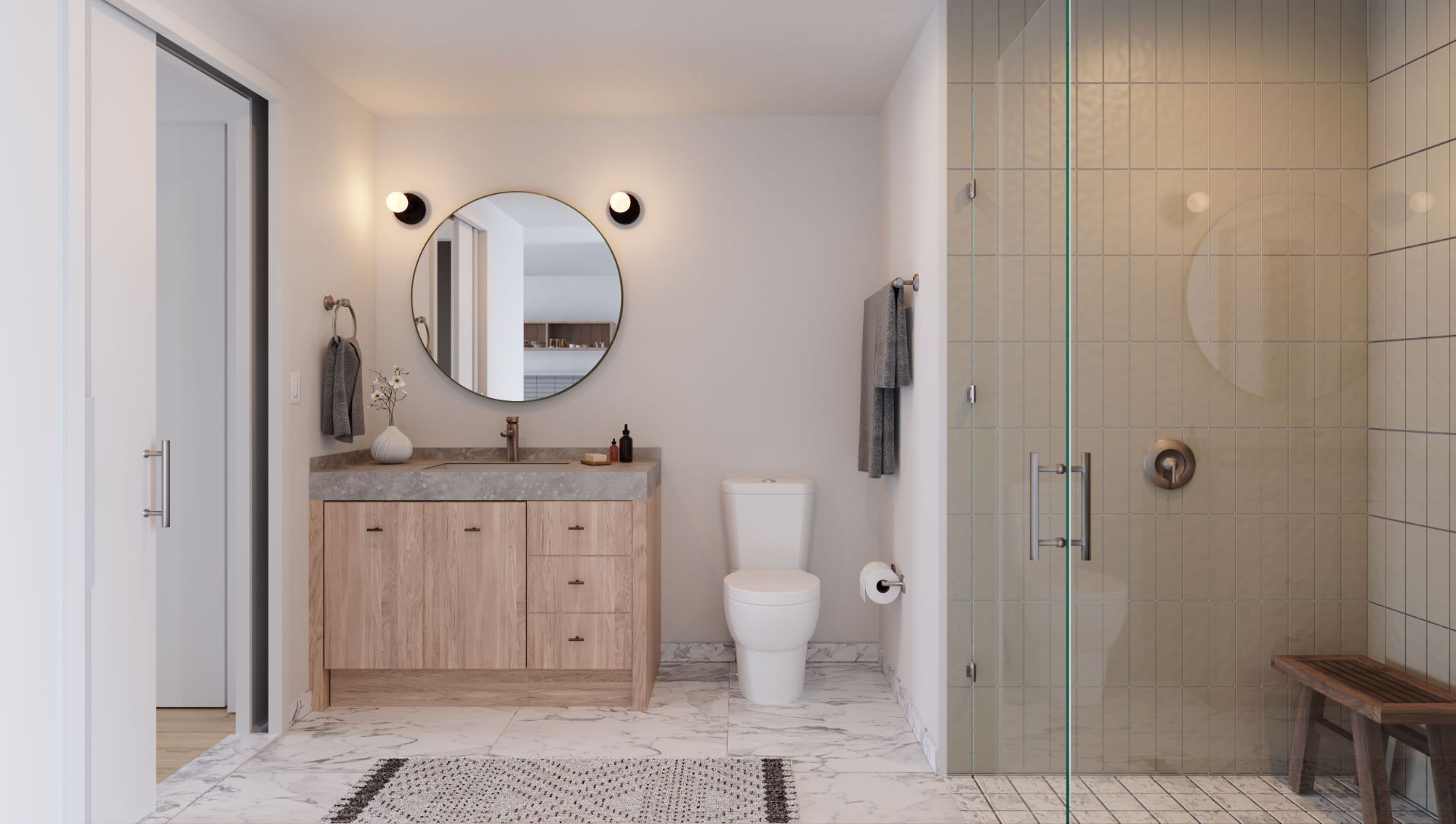 Modern bathroom with wooden vanity, round mirror, toilet, and glass shower enclosure.