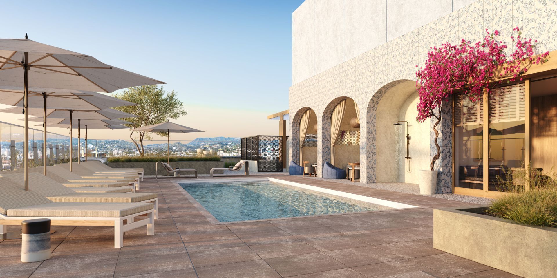 Modern resort patio with pool, lounge chairs, umbrellas, and ocean view at sunset