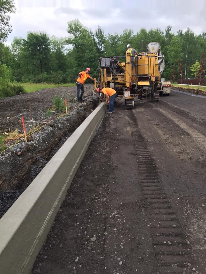 Une bordure en béton est en construction sur le bord d'une route