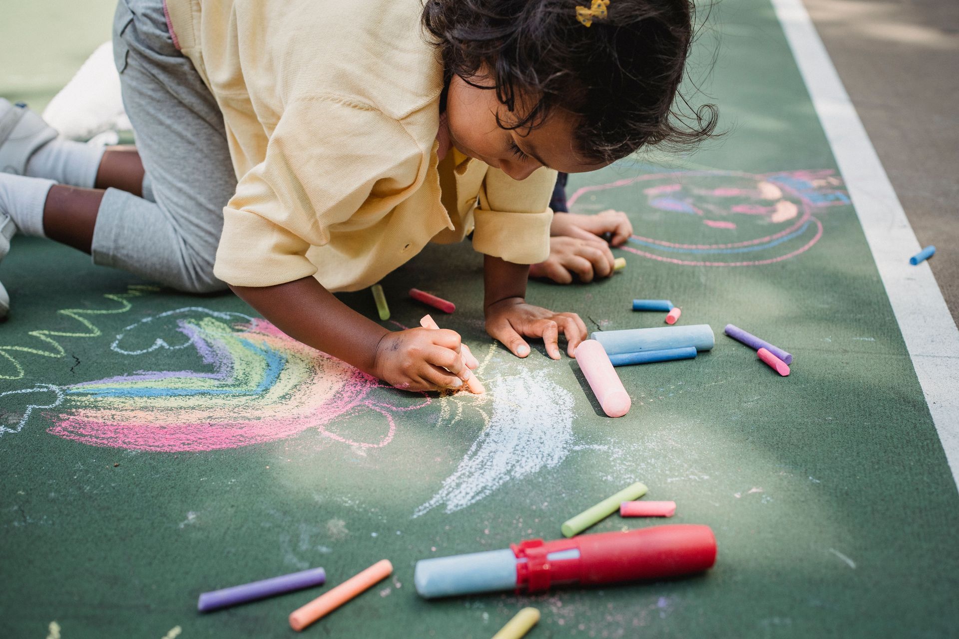 Little kid drawing with chalk