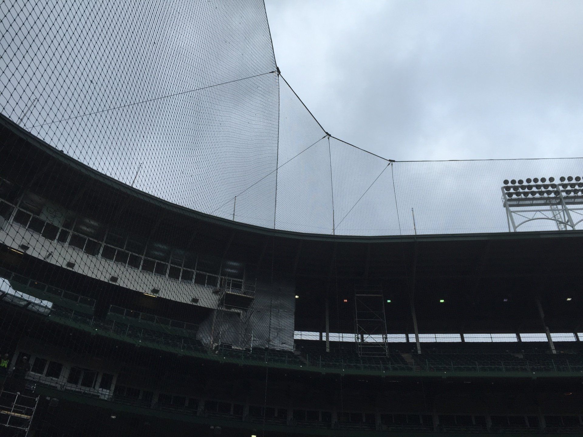 The inside of a baseball stadium with a net covering the stands