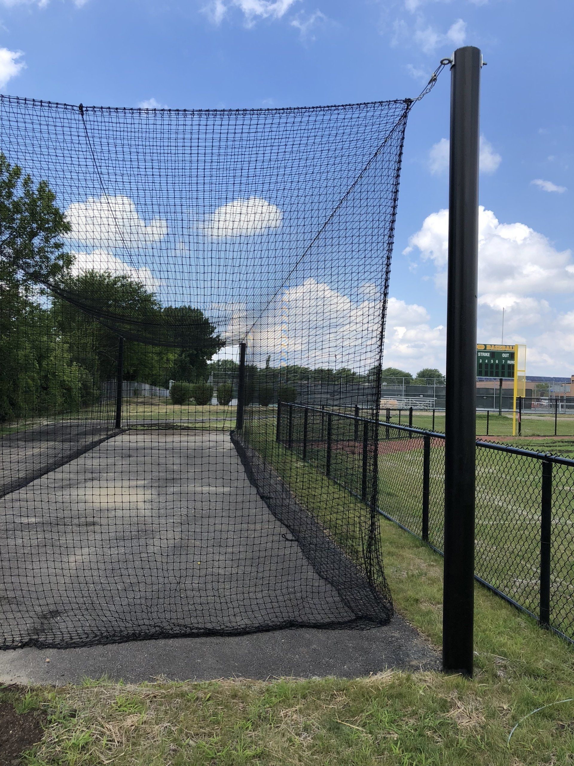 A baseball net is hanging over a baseball field.