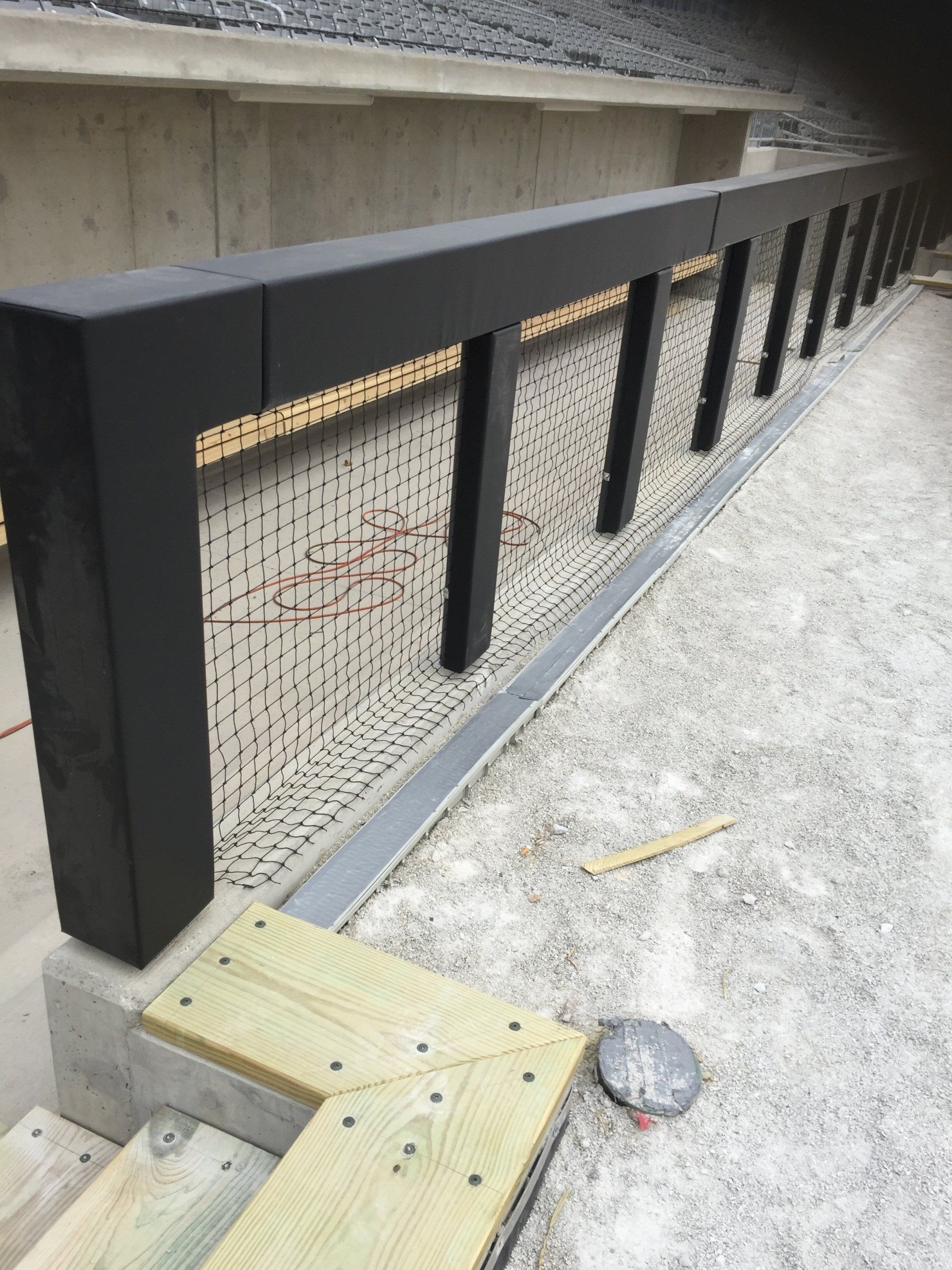 A black railing is being built on top of a wooden deck