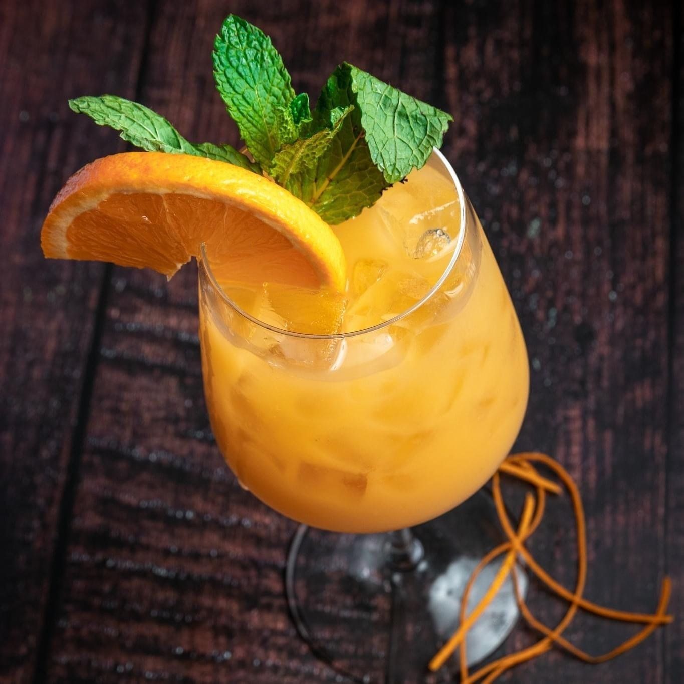 A glass of orange juice with a slice of orange on top