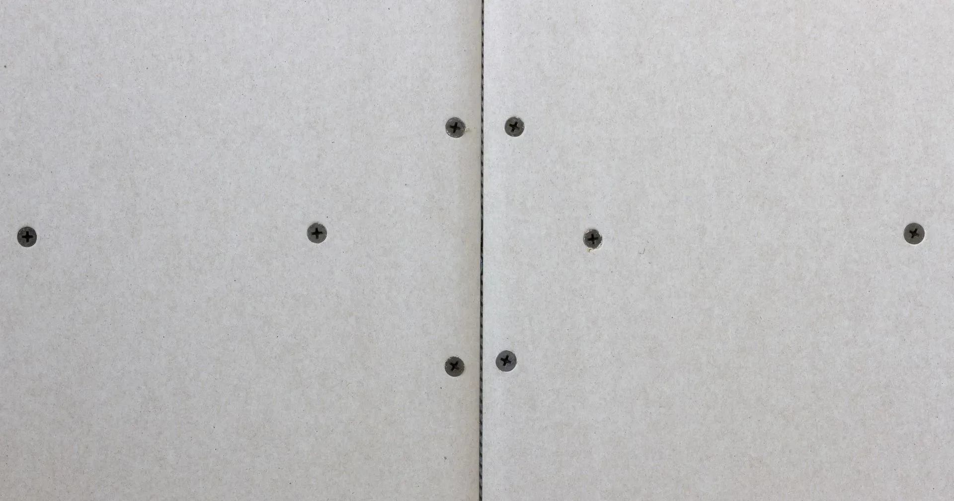 Close-up of a gray metal cabinet with two vertical doors and small black screws.
