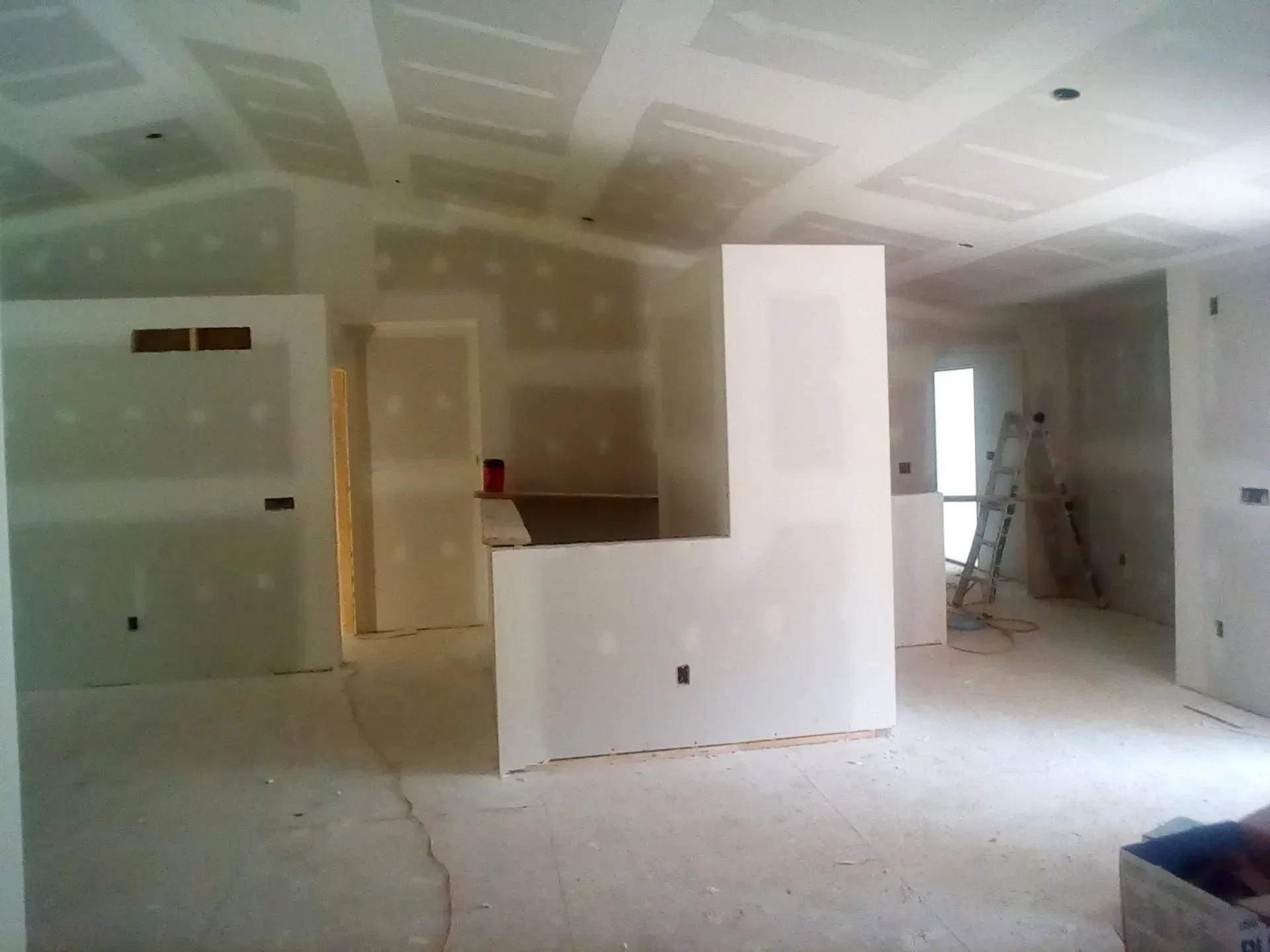 Unfinished room with drywall, ladder, and partially built partition walls
