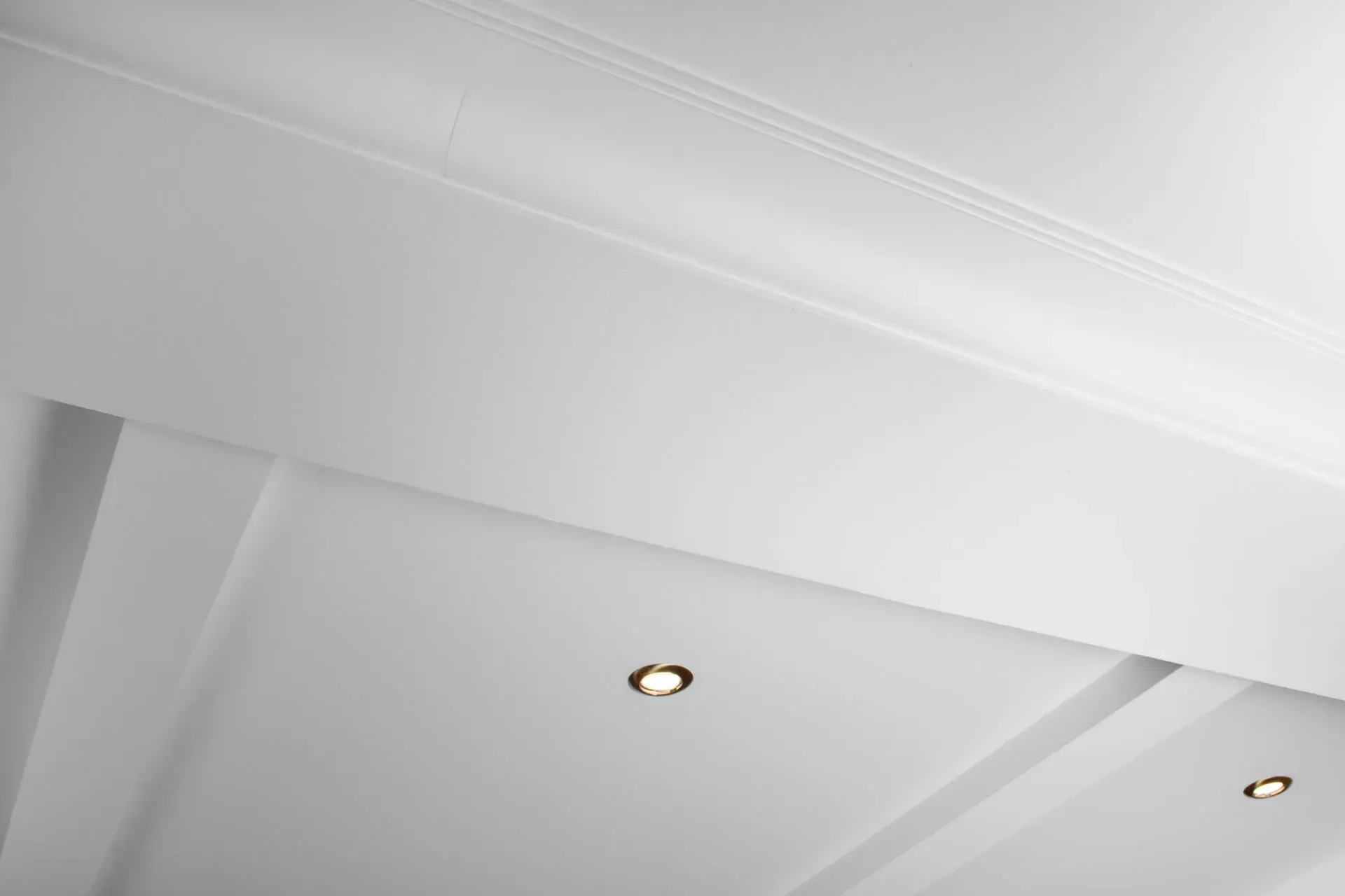 White ceiling with recessed lights and decorative trim