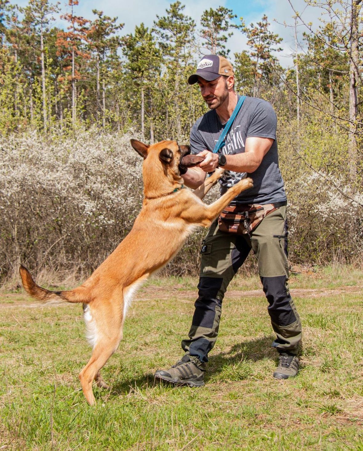 ein Mann spielt mit einem Hund und trägt ein T-Shirt mit der Aufschrift survival