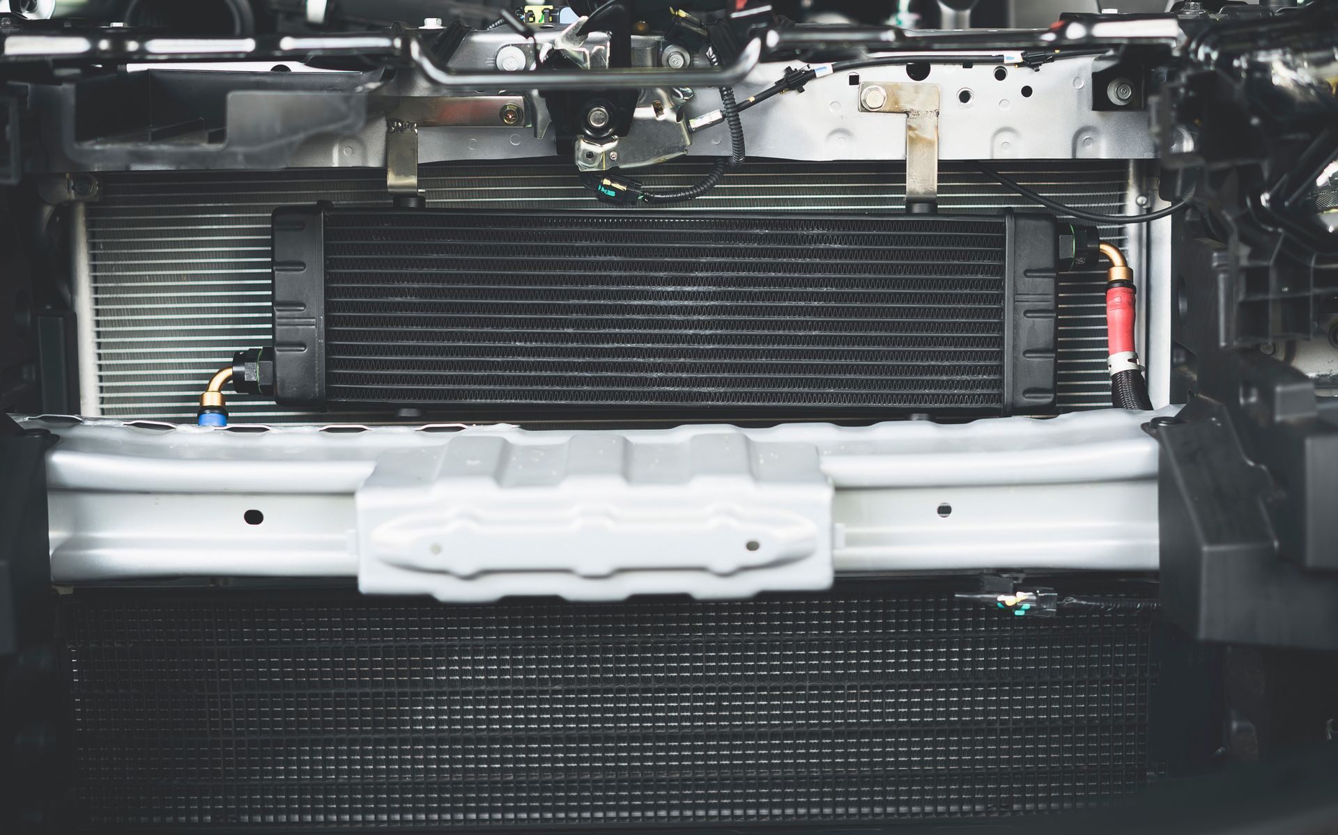 Car engine compartment with a black intercooler and other components — P.K. Head Servicing & Reconditioning in Warilla, NSW