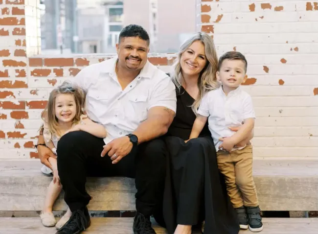 A large white house with a gray roof is sitting on top of a lush green lawn.