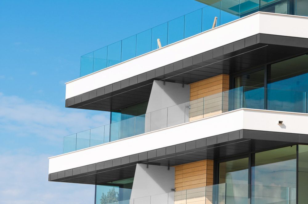 Modern Building Exterior With Glass Balconies, Against a Blue Sky — Curtis Strata in Byron Bay, NSW