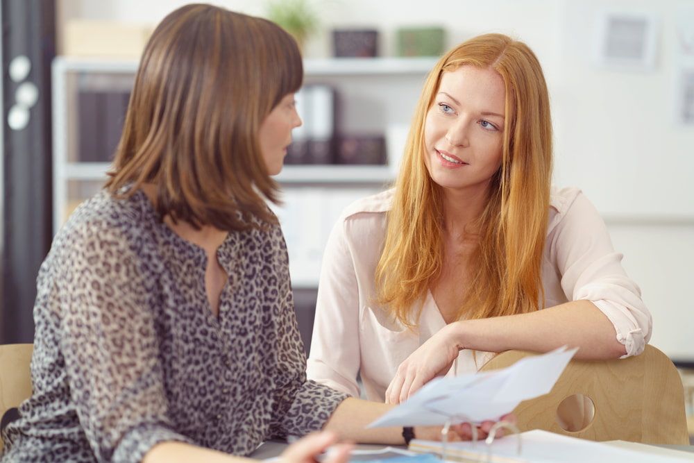 Two Women in Office Discuss Documents and Holding Papers — Curtis Strata in Casino, NSW