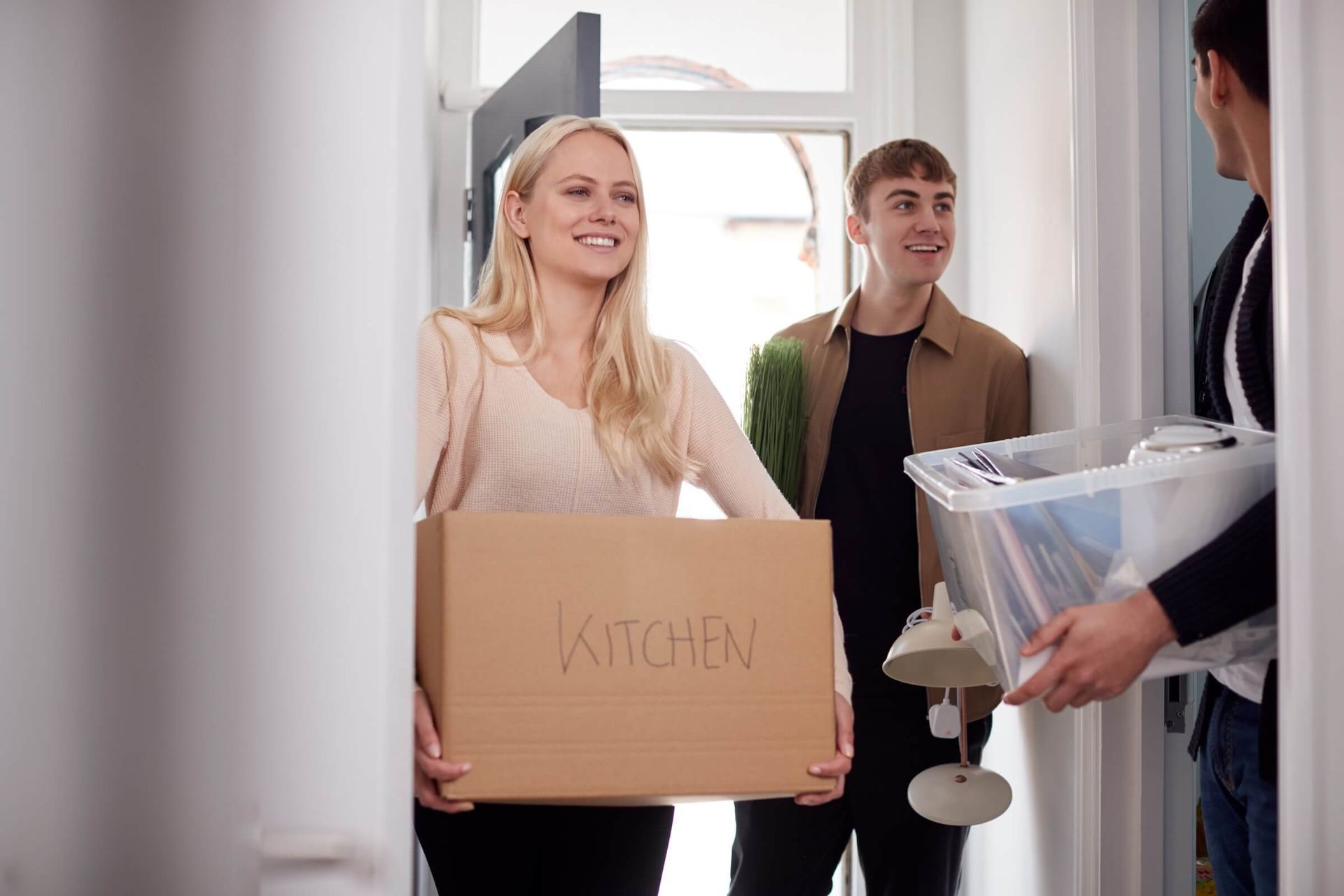 Female OSU student carries moving box into her Corvallis apartment