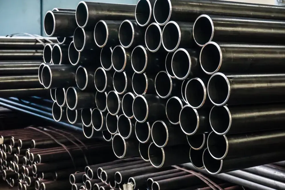 Piles of Black Metal Pipes, Stacked in a Workshop or Storage Area — Independent Scrap Metal Pty Ltd in Maclean, NSW