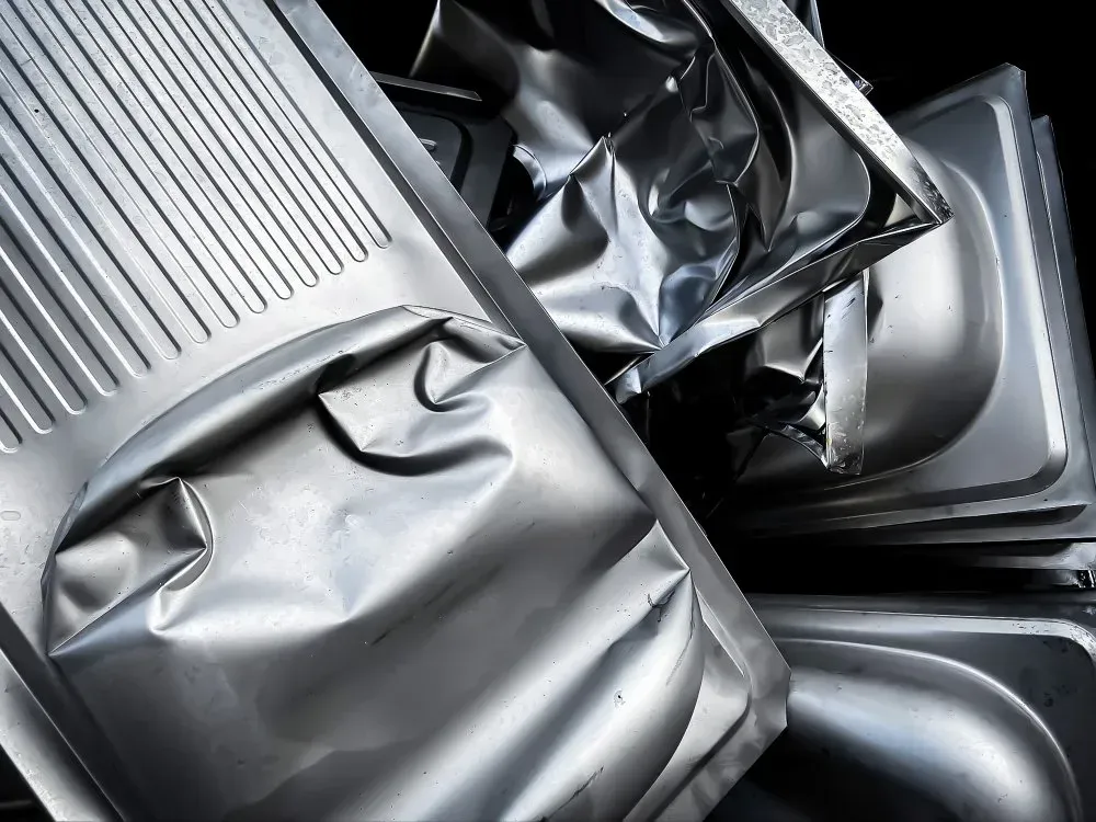 Crushed, Silver Metal Food Trays Piled Together — Independent Scrap Metal Pty Ltd in Evans Head, NSW