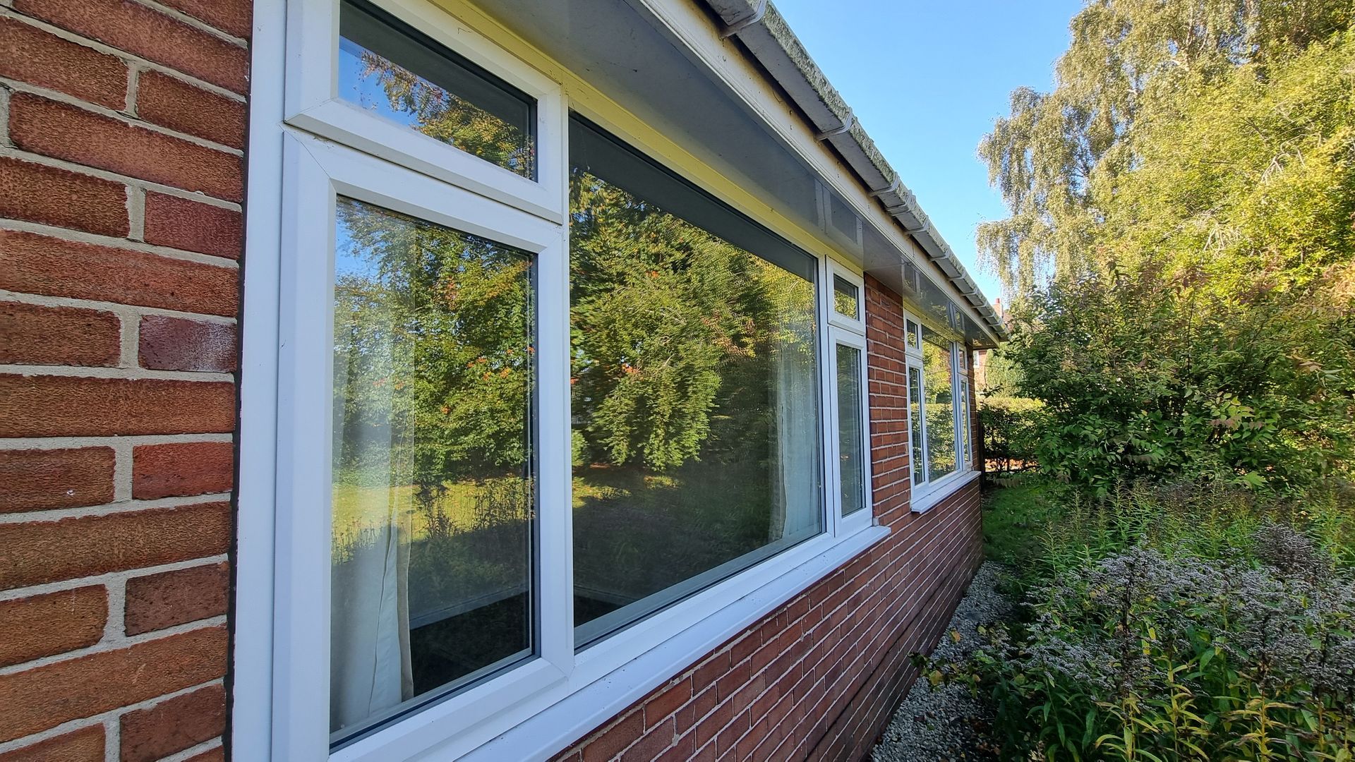 Bungalow with two very large windows that have just been cleaned.