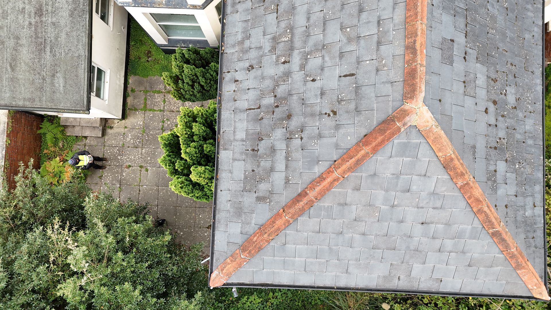 Aerial drone photograph of an old property taken as a drone roof survey showing slate tiles and, ridge tiles