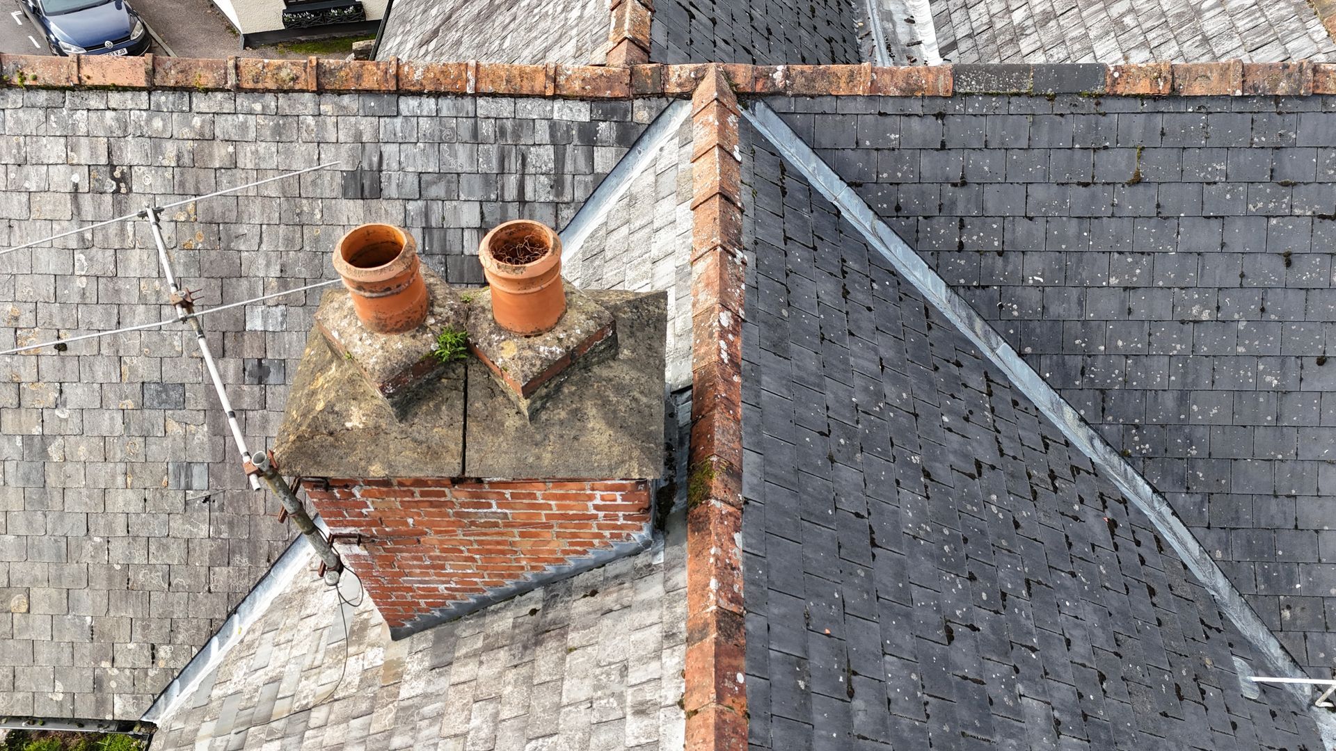 Aerial image of an old property taken as a drone roof survey showing slate tiles and, ridge tiles and chimney stac