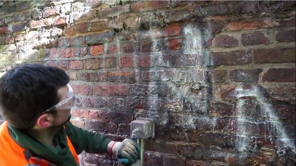 Graffiti on wall being removed with ThermaTech Steam Cleaner