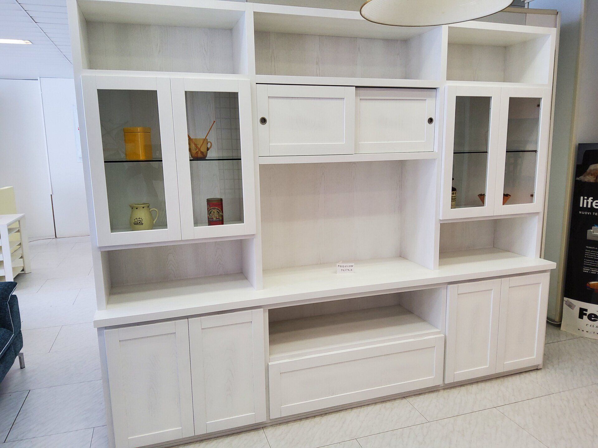 Mobile TV in legno bianco con ante in vetro e porte scorrevoli.