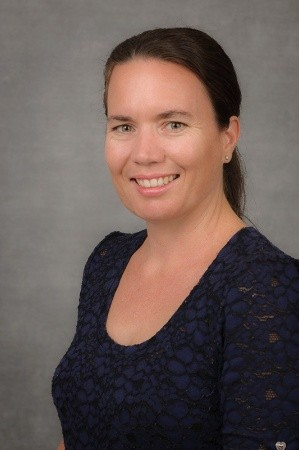 A portrait of Angela Hodges - a woman in a blue shirt is smiling for the camera.