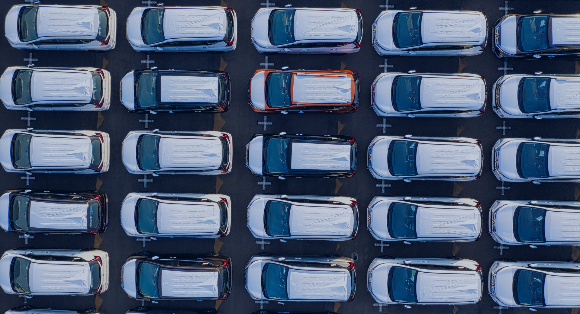 An aerial view of a parking lot filled with lots of cars.