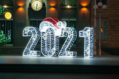 The numbers 2021 are made of lights and have a santa hat on them.