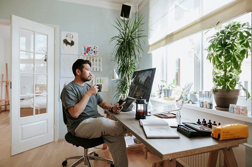 A man is sitting at a desk in front of a computer.