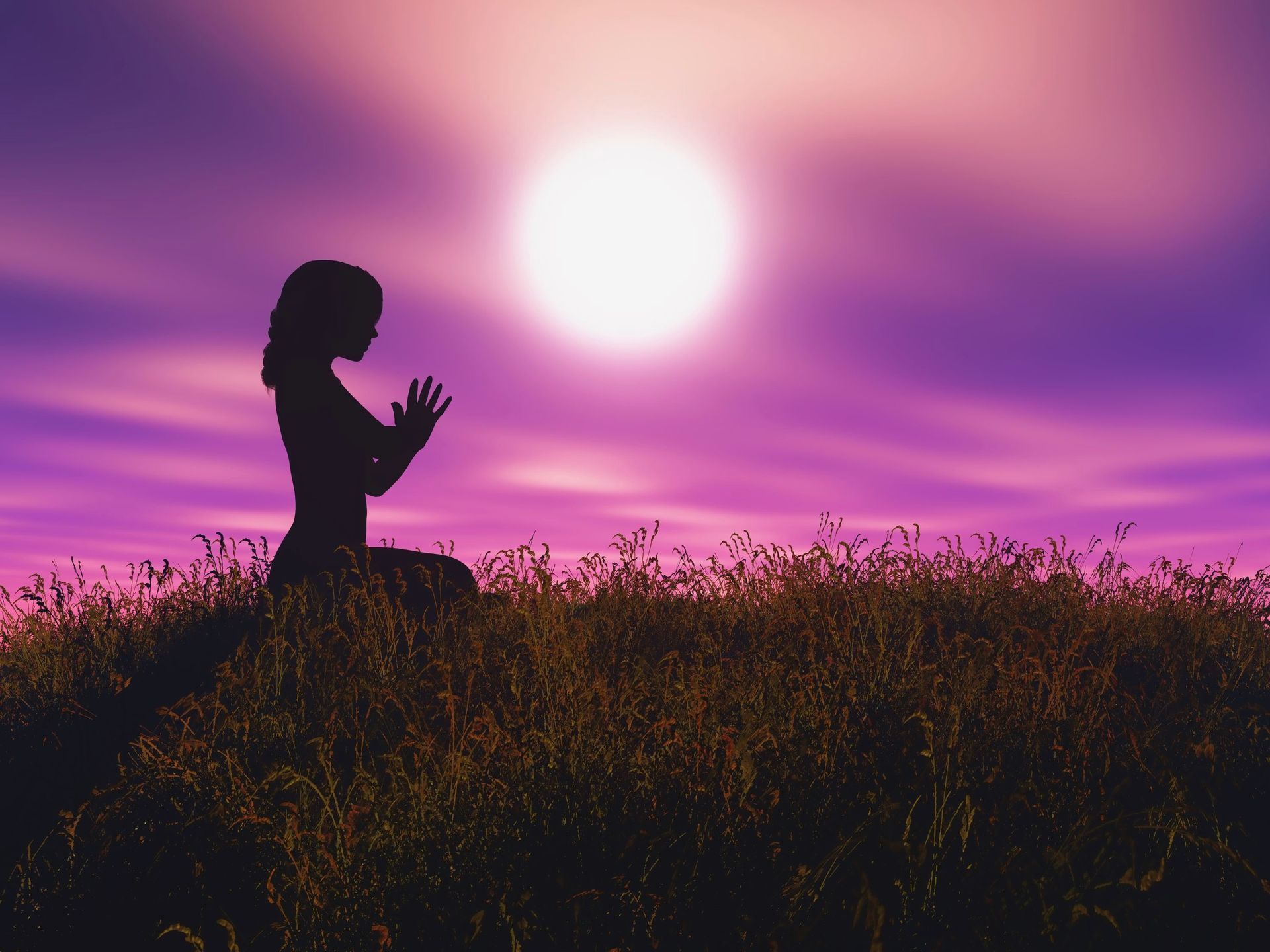 A woman is sitting on a yoga mat on the beach with chakras surrounding her.