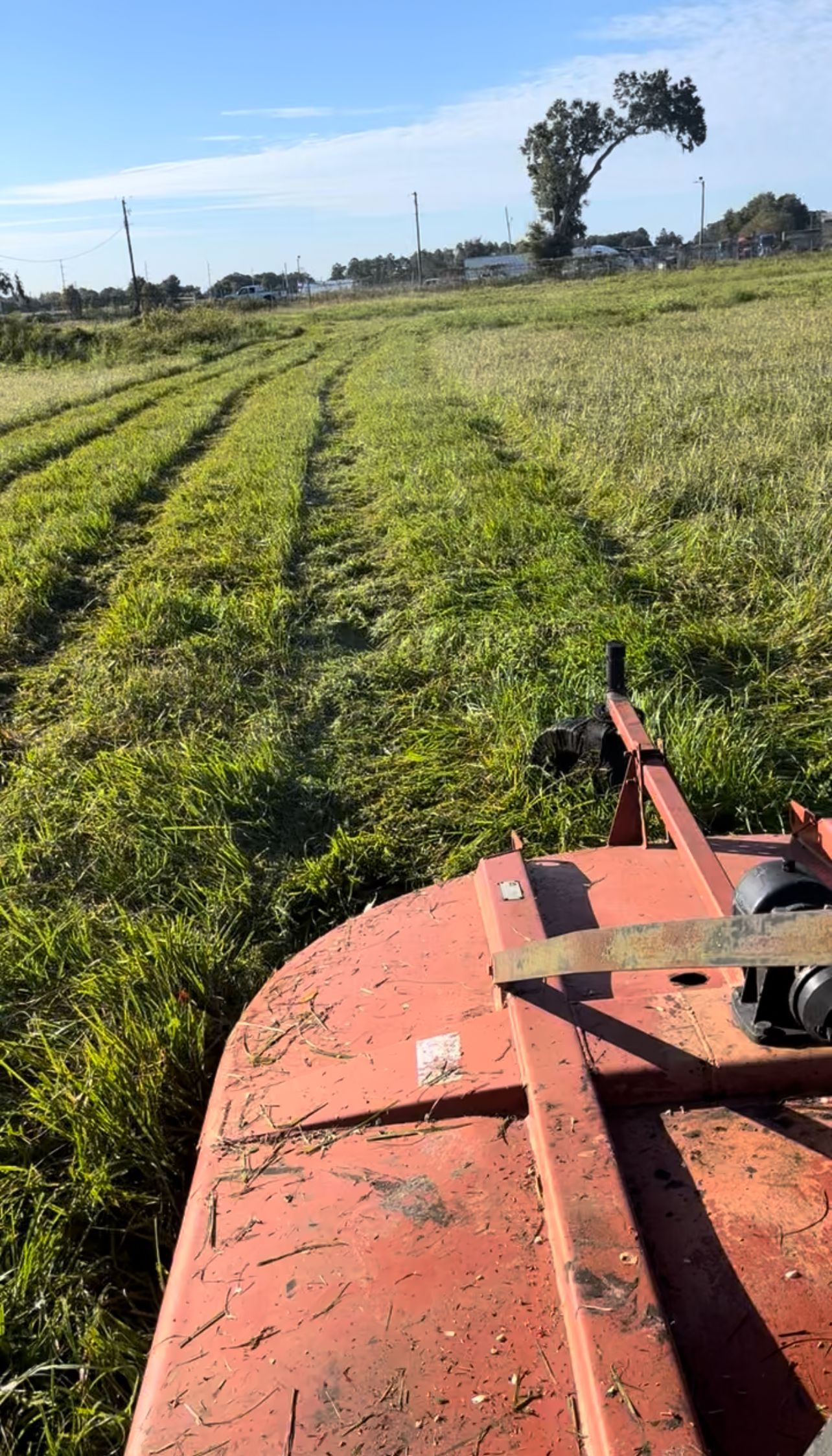 A tractor is cutting grass in a field.