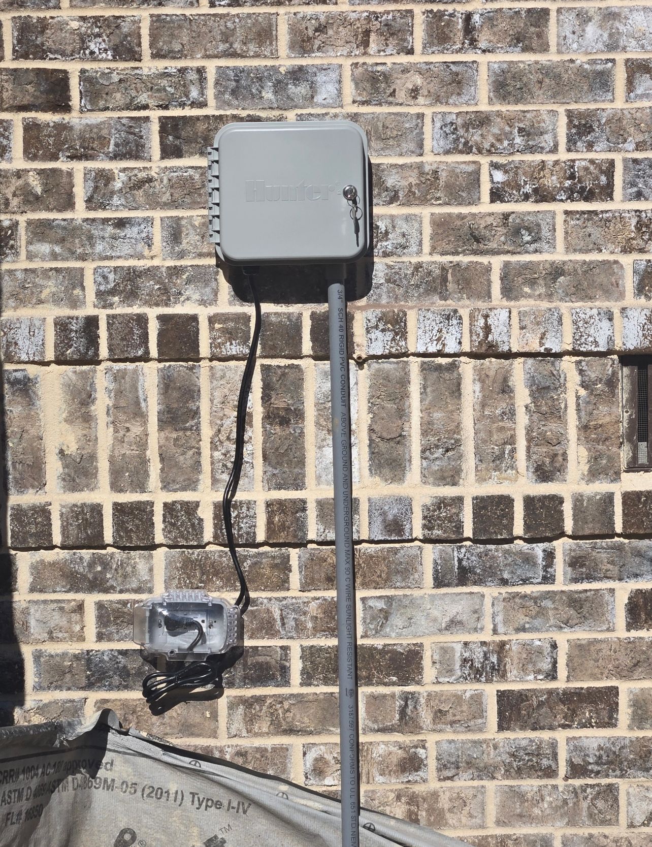 A brick wall with a box attached to it