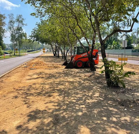 Orange Skid-steer Loader Parked by Trees and a Road — iWater NT Pty Ltd in Yarrawonga, NT