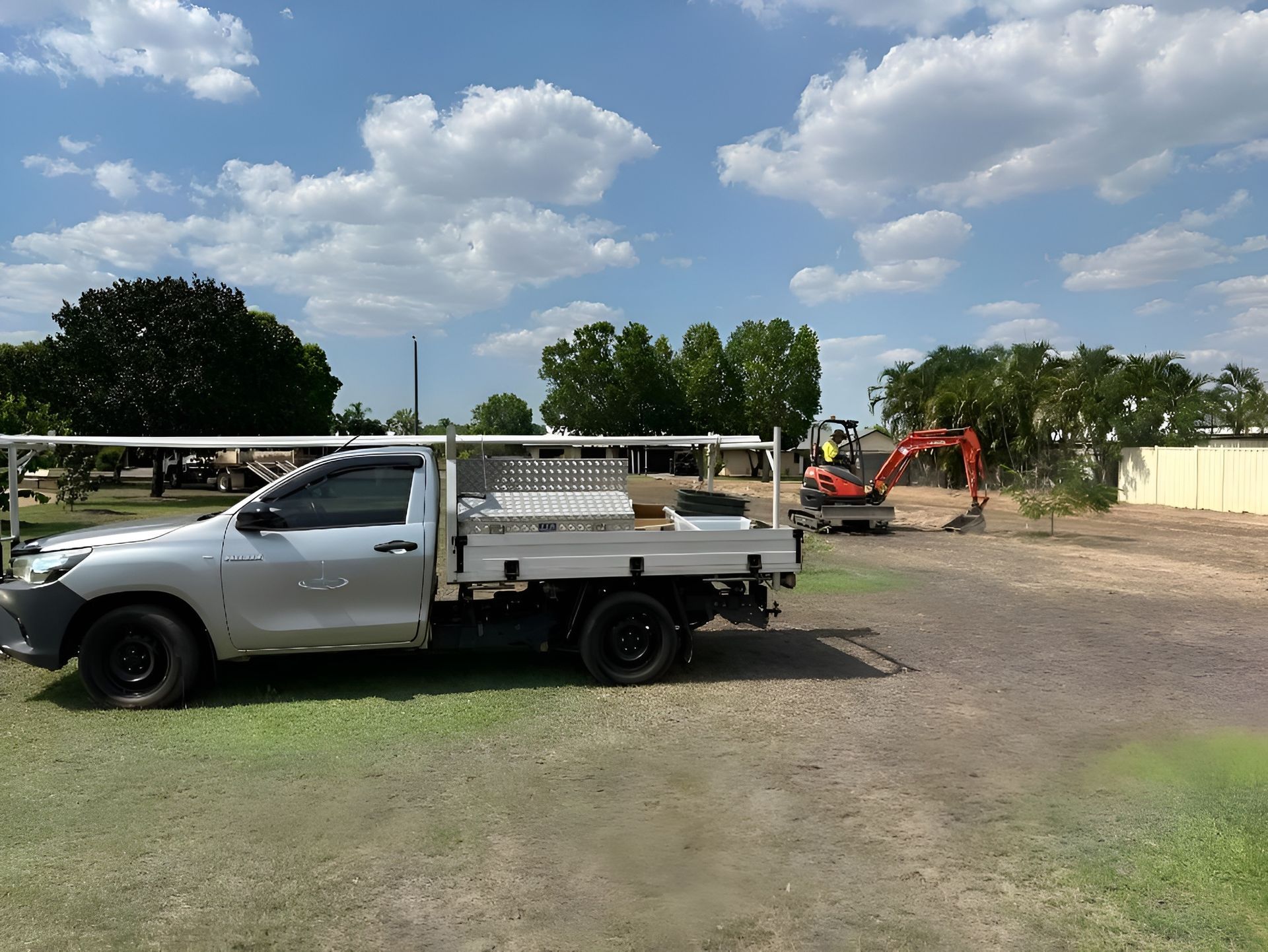 A Work Truck Parked on Grass, With an Excavator and Construction — iWater NT Pty Ltd in Yarrawonga, NT