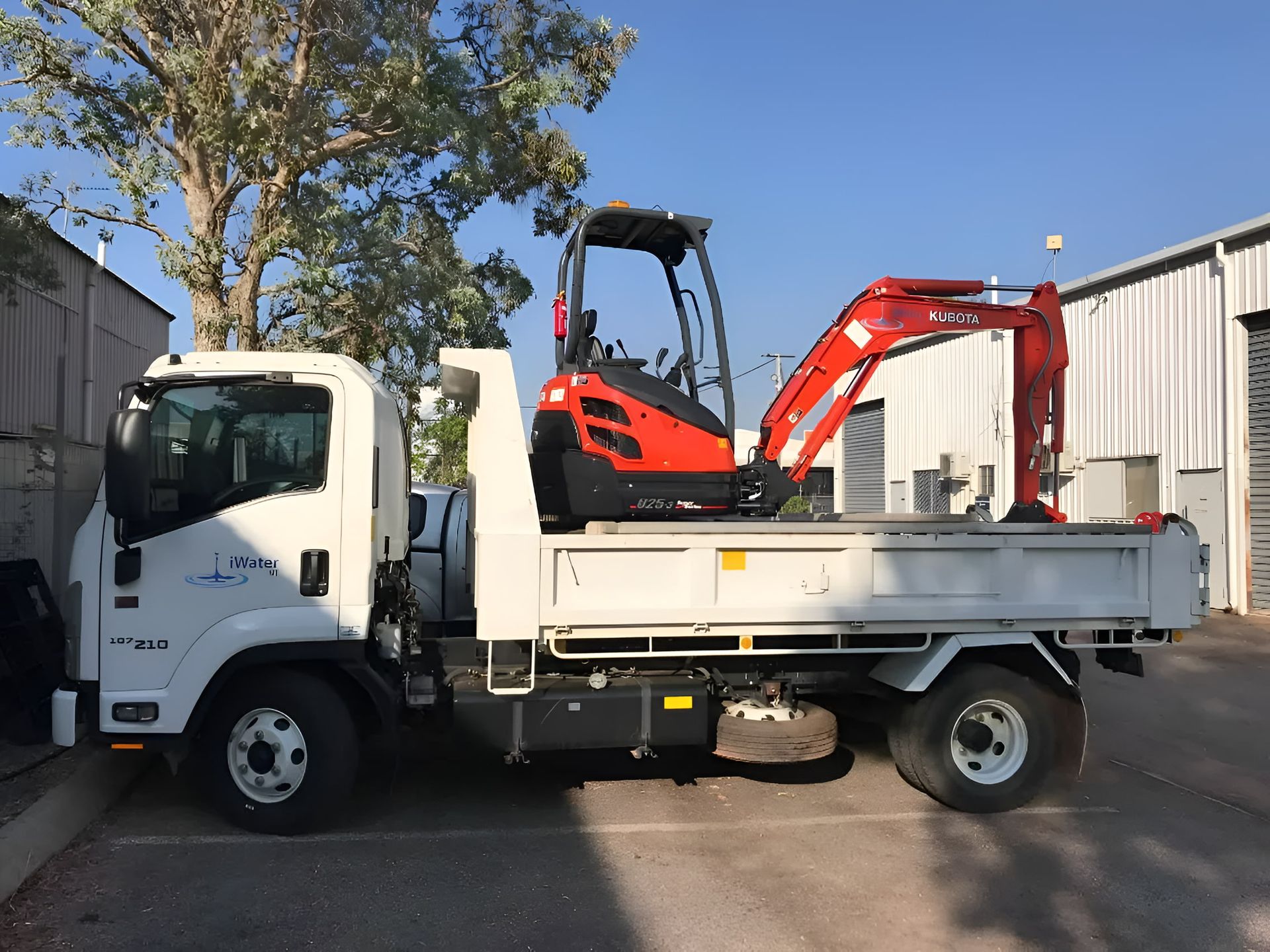 White Truck With Red Excavator on the Flatbed — iWater NT Pty Ltd in Yarrawonga, NT