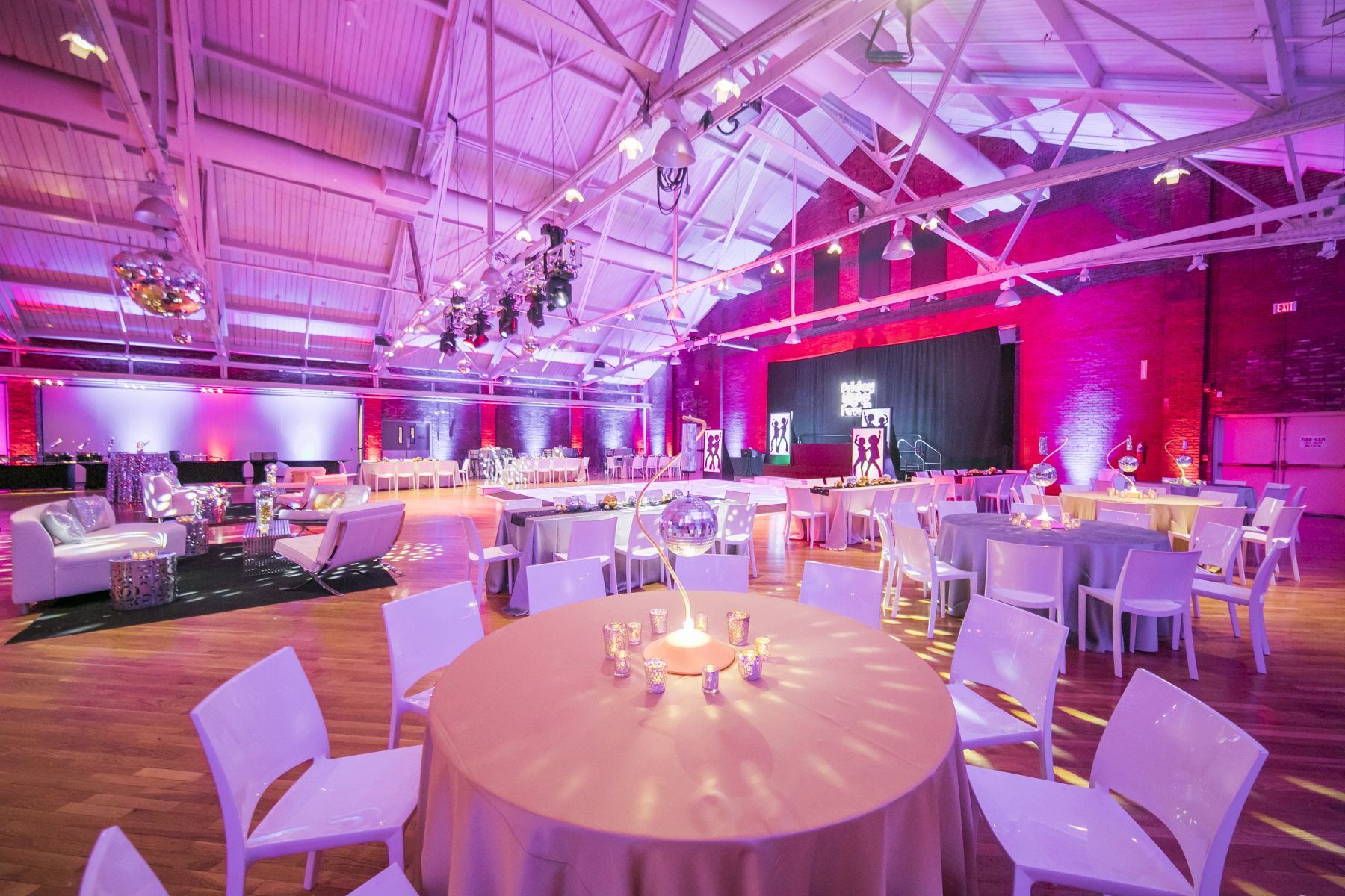 A large room with tables and chairs set up for a party.