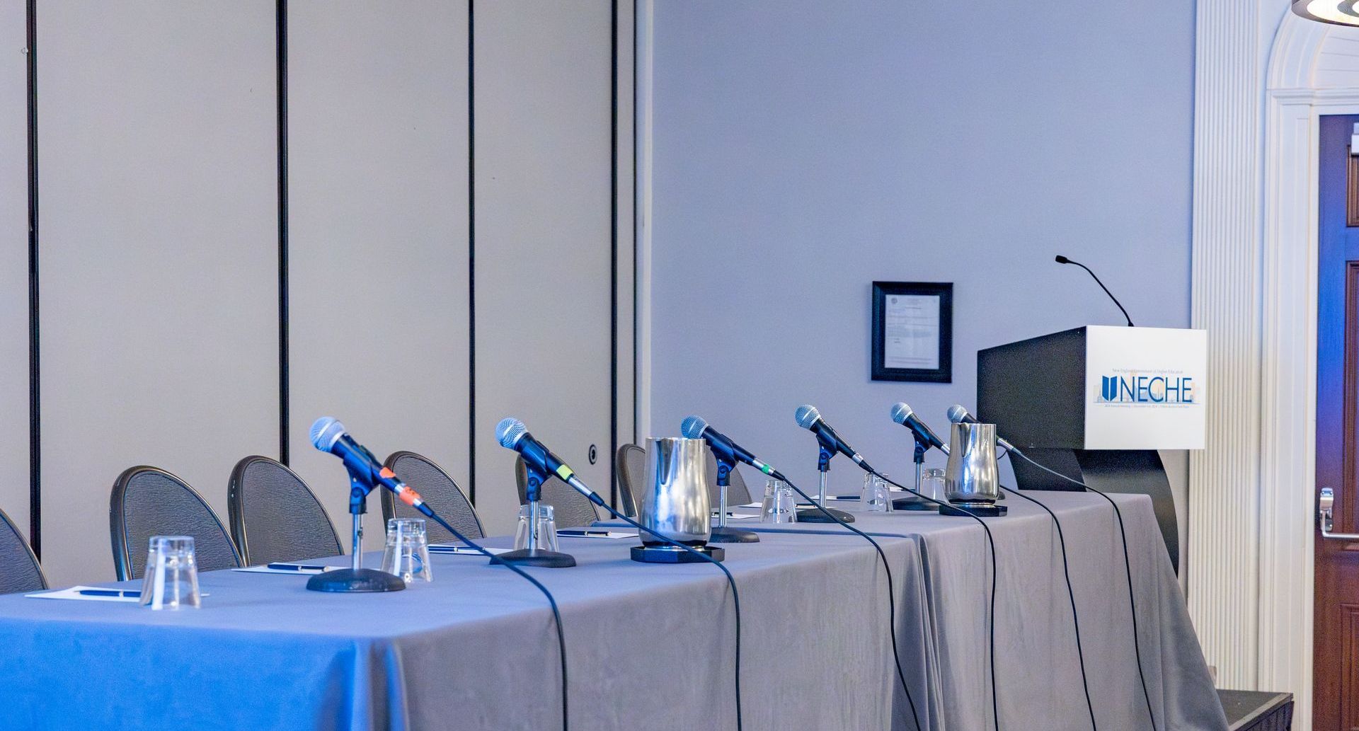 A conference room with a long table and a podium