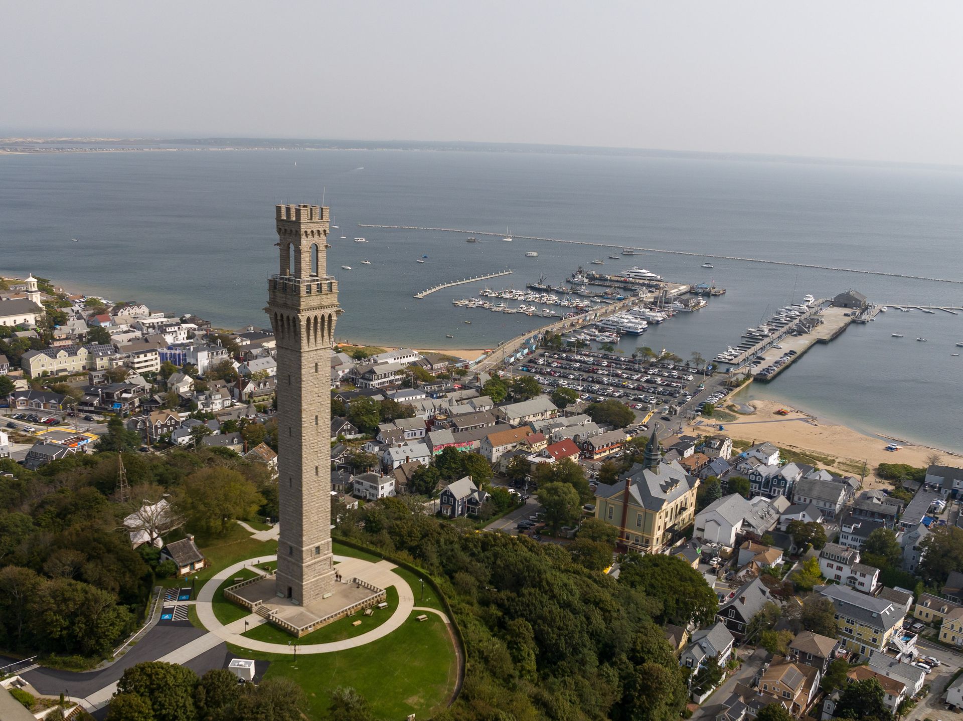 An aerial view of a tower on top of a hill overlooking the ocean.