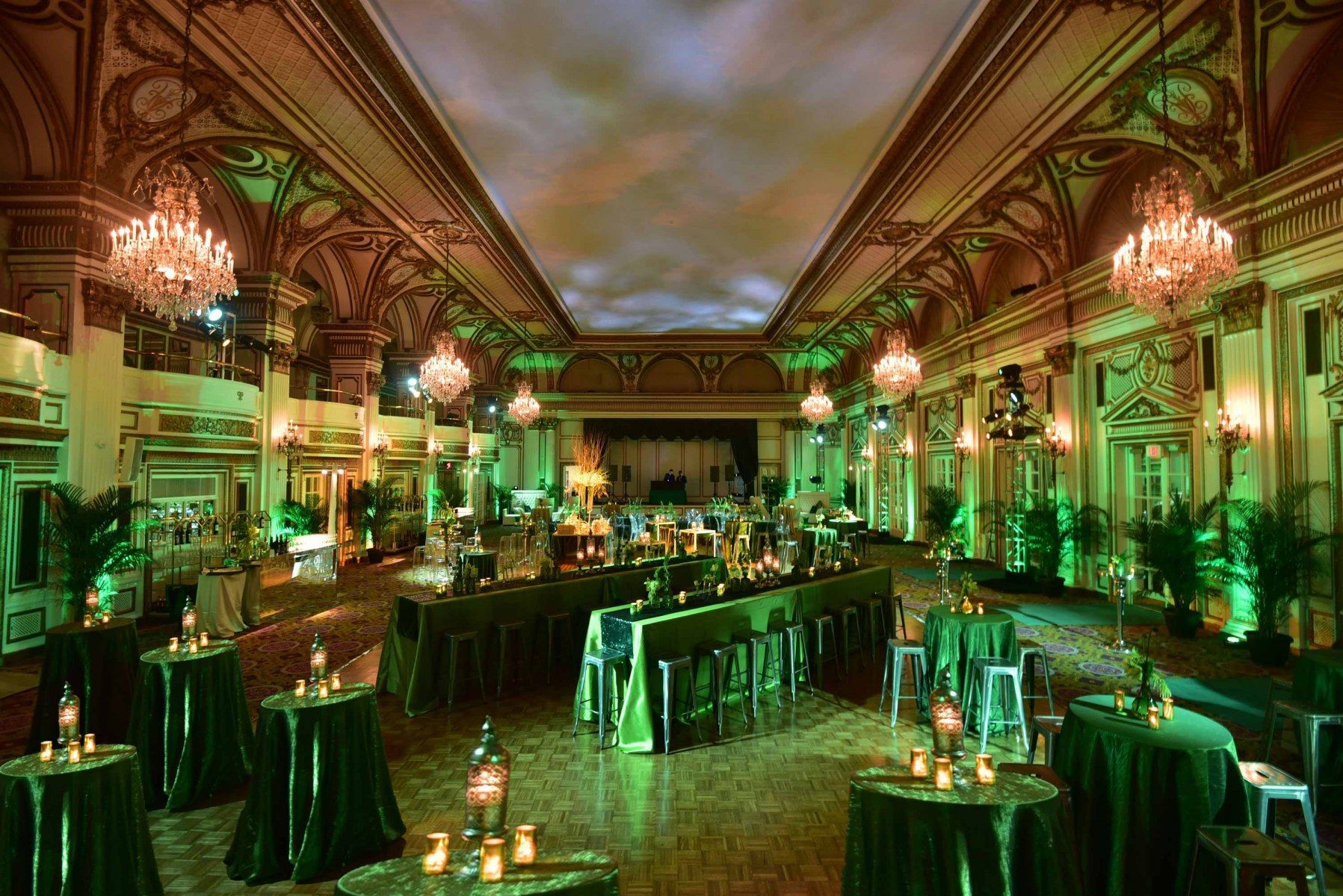 A large room filled with tables and chairs and green lights.