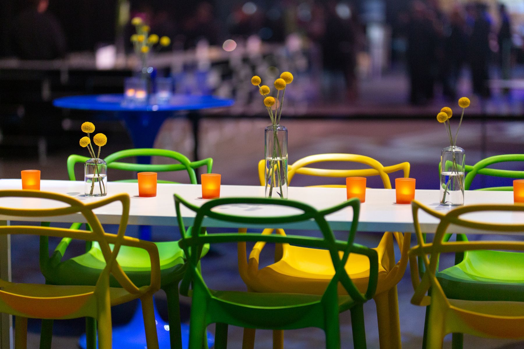 A row of colorful chairs are sitting at a table.