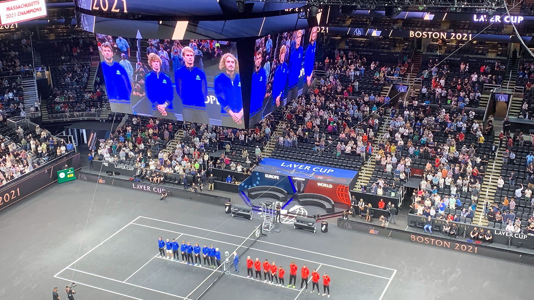 A tennis match is being played in front of a large crowd
