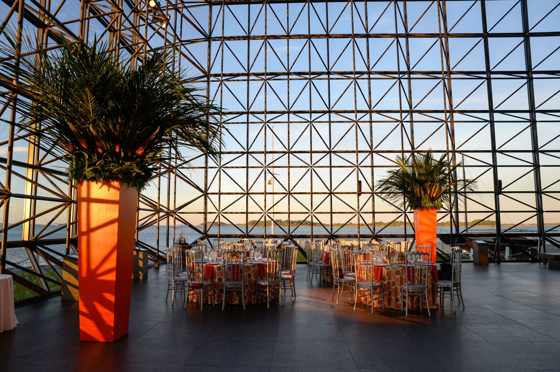 A large glass building with tables and chairs in it