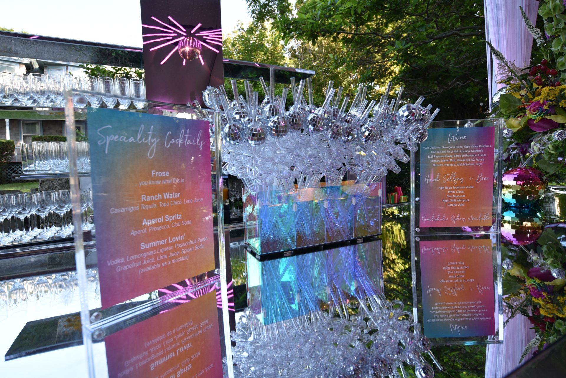 Seating chart with holographic signs, iridescent accents, and crystal decorations at outdoor event.
