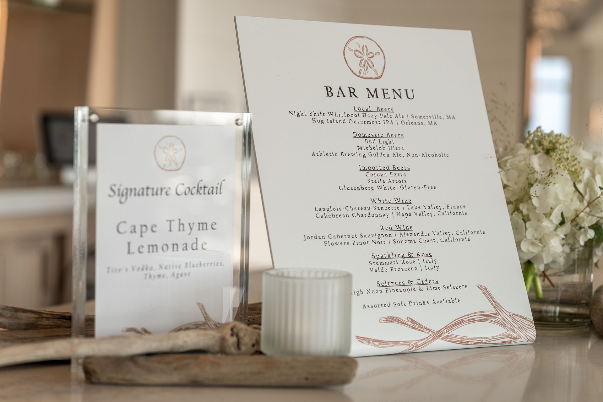 Bar menu with a signature cocktail sign and a candle.