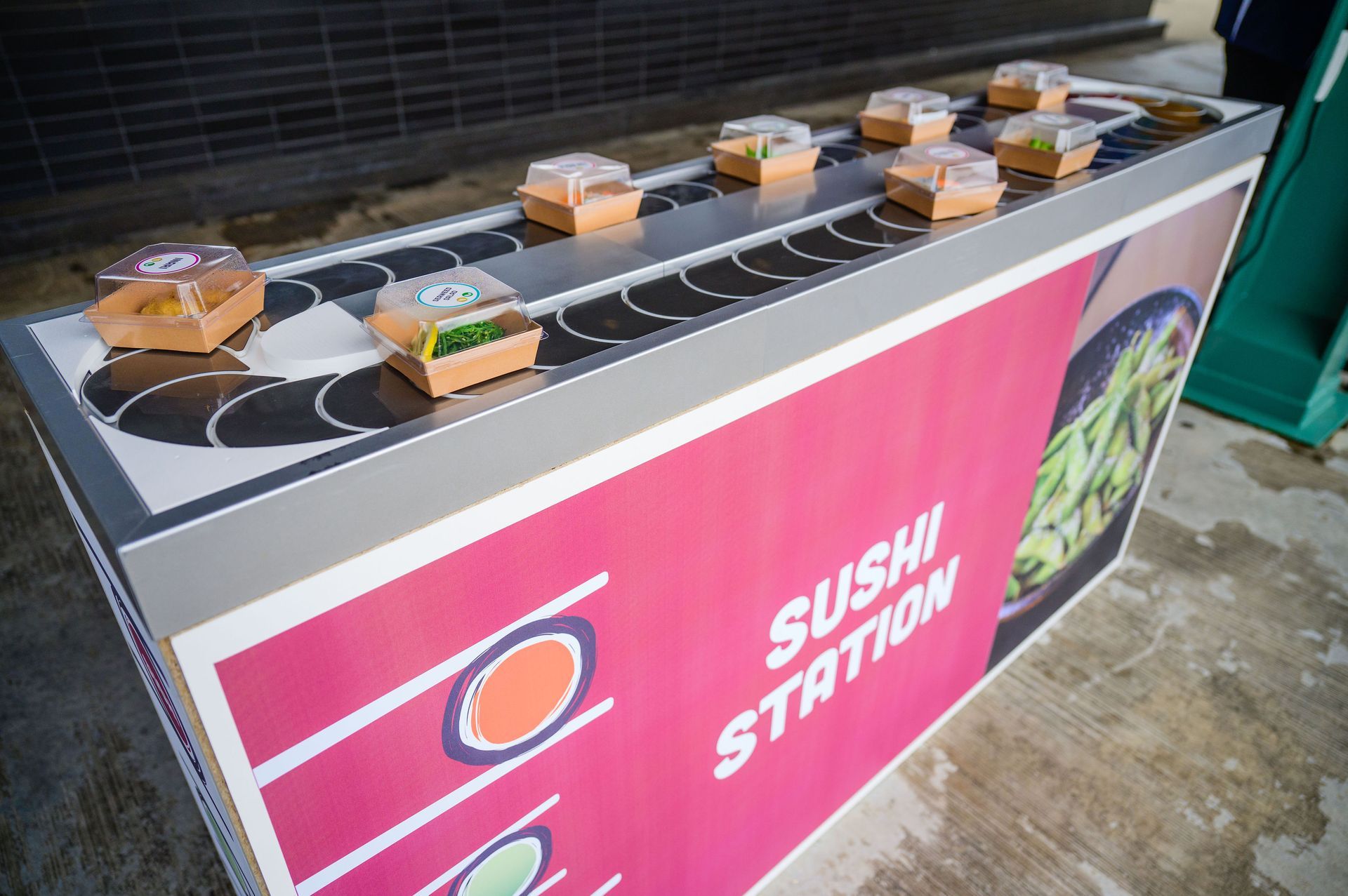 Sushi station with a conveyor belt holding sushi boxes.